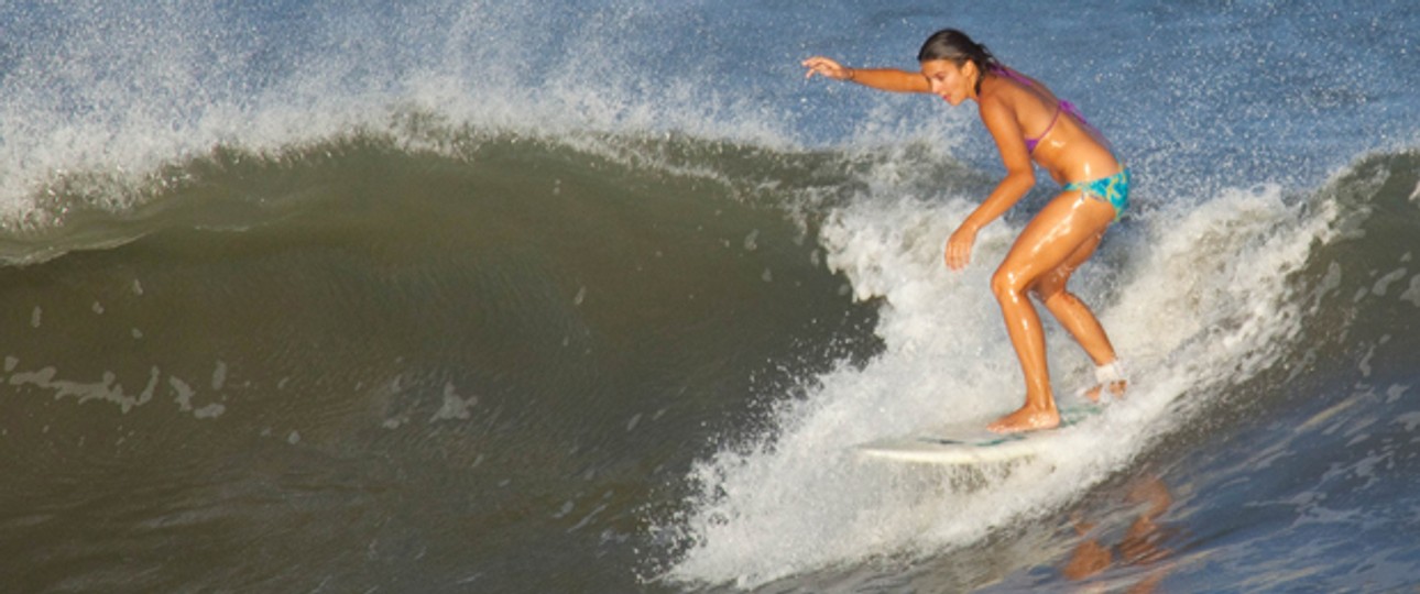 Surferin auf einer Welle: Ihr Hobby kann teuer werden.