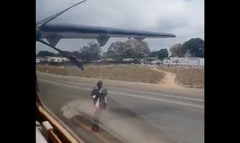 Der Mann tanzt vor einem startenden Flugzeug.