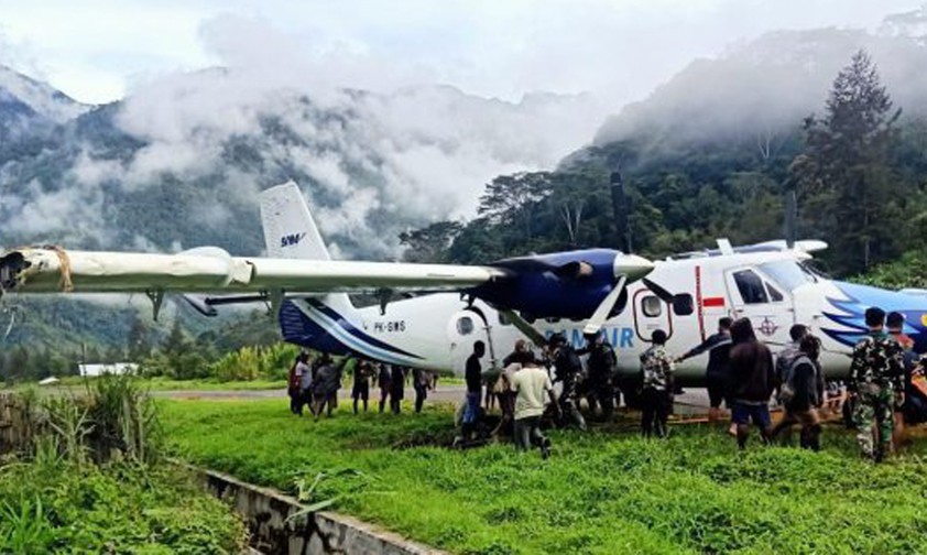 Bewohner ziehen Twin Otter mit Seil aus Morast