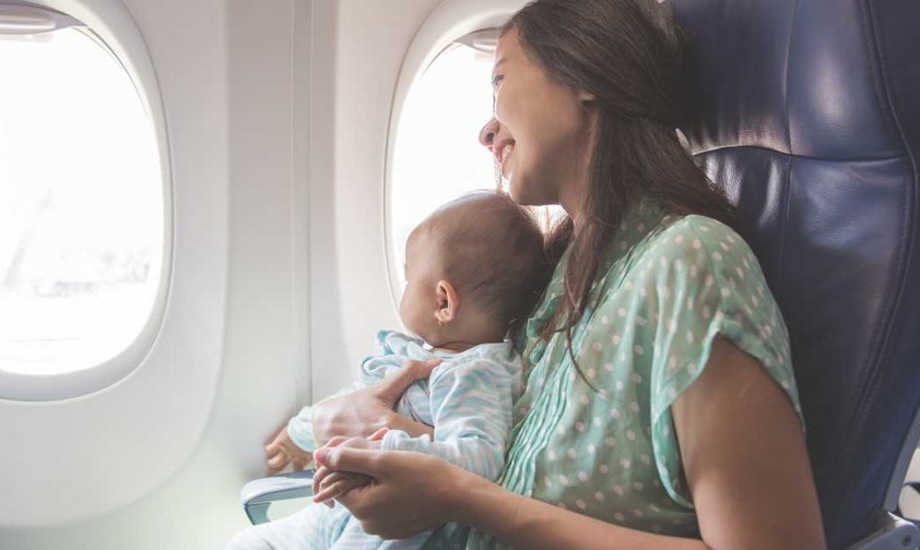 Eine Mutter mit ihrem Baby im Flugzeug: Babys sollen in den USA künftig besser gesichert werden.