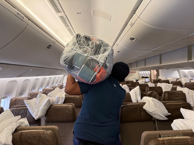 Neue Kopfhörer werden in grossen Säcken ins Flugzeug gebracht und an jedem einzelnen Sitzplatz montiert.