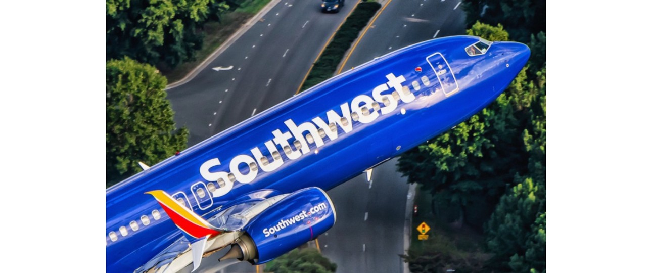 Boeing 737-800 von Kapitän Ted Orris beim Abschiedsflug: Die Aufnahme wurde aus einem Hubschrauber fotografiert, in die Kamera winkt Orris' Kopilot.