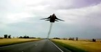 Ziemlich tief fliegt diese SU-24 über der Straße.