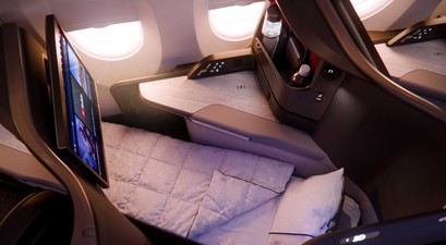Ein Sitz der Delta One Suite im A350-1000 als Bettmodus mit Decke