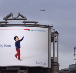Riesenbaby zeigt auf kleines Flugzeug: Süß oder unheimlich?