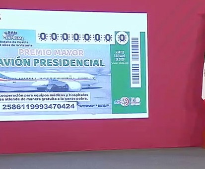 Andrés Manuel López Obrador presents the raffle ticket.