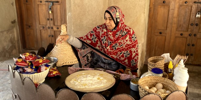 ... Hof eine Frau eine Art Crêpes zubereitet.