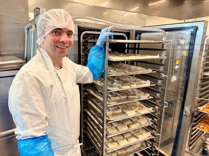 Ein Angestellter hat Fisch gekocht.