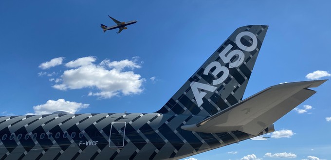 Zu sehen auf der ILA Berlin 2022: Airbus' A350-900-Testflieger mit dem Kennzeichen F-WWCF, darüber ein Jet von Icelandair, der am BER gestartet ist.