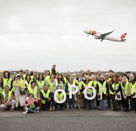 Mitarbeitende am Flughafen Porto: Im Hintergrund ein Flugzeug von Tap.