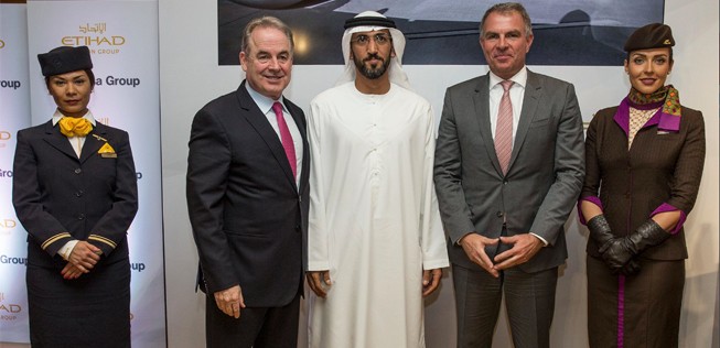 Etihad-Lenker James Hogan (l.), Etihad-Vorstand Mohamed Mubarak Al Mazrouei (M.),  Lufthansa-Chef Carsten Spohr (r.) mit zwei Flugbegleiterinnen nach Unterzeichnung des Abkommens.