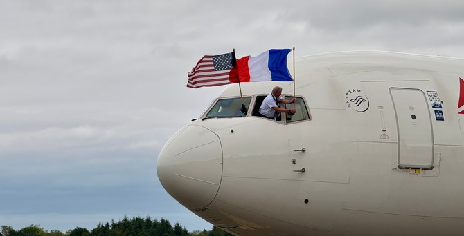 Kapitän Jim Butterworth befestigt Flagge der USA und Frankreichs außen am Cockpit: Flug mit Veteranen in die Normandie.
