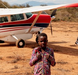 Kinder in Tansania freuen sich über die Ankunft des Fliegers von MAF.