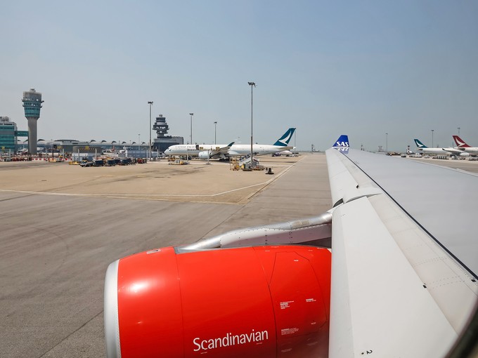 Typisch Hongkong: Der Kontrollturm und Heckflossen von Jets von Cathay Pacific und Cathay Dragon.