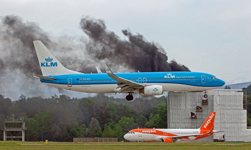 Eine Maschine von KLM fliegt am brennenden Gebäude ...