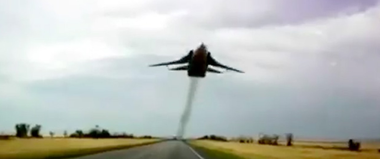 Ziemlich tief fliegt diese SU-24 über der Straße.
