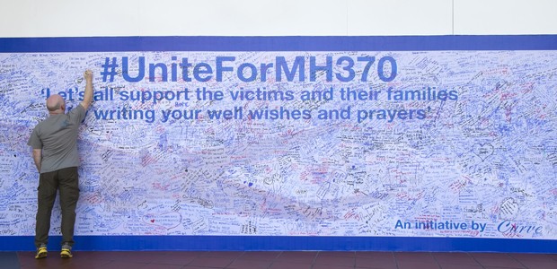 Hoffen und beten: Ein Mann in Kuala Lumpur schreibt an eine Gedenkwand für die Opfer von Flug MH370.