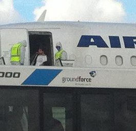 Männer mit Schutzanzügen vor dem Flugzeug: Noch hat sich der Verdacht nicht bestätigt.