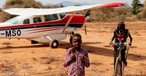 Kinder in Tansania freuen sich über die Ankunft des Fliegers von MAF.