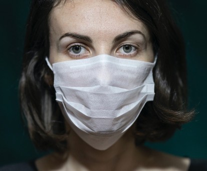 Frau mit Atemmaske: Schutz ist essenziell auf Reisen.