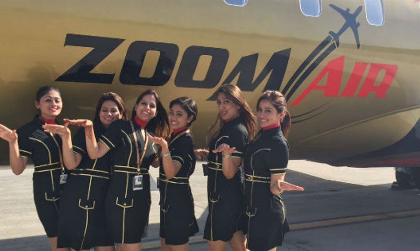 Flugbegleiterinnen von Zoom Air vor einem Flugzeug: Die Fluggesellschaft plant mit einem Wachstum von 20 Prozent pro Jahr.