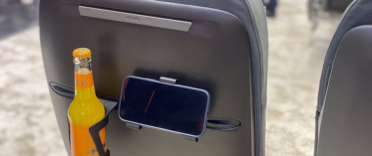 Economy-Sitz von Recaro mit eingeschobenem Flaschen- und Handhalter: Spart Gewicht.