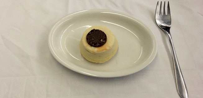 Das Dessert: Gebackener Käsekuchen mit einem Schokoplättchen darauf.