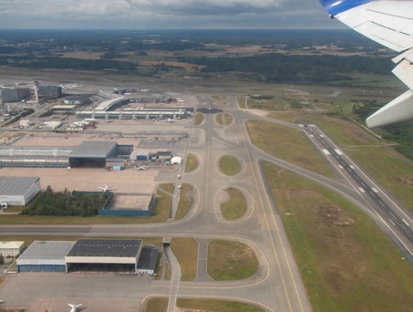Blick auf eine Flughafen aus der Luft: Piste, Rollwege und Vorfeld.