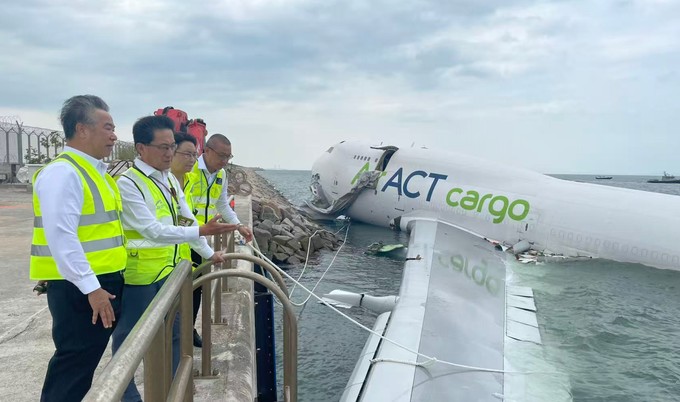 Flughafenmanagement und Flugzeugwrack betrachten das Wrack der Boeing 747.