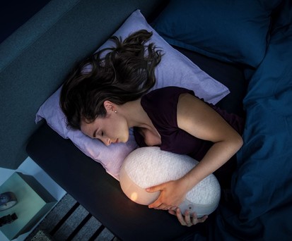 Roboter im Arm: Frau mit Somnox-Gadget.