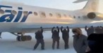 Passagiere packen mit an: Die Tu-134 wurde aus dem Eis befreit.