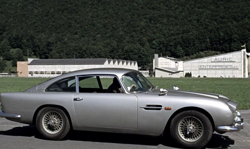 James Bond und sein Aston Martin vor der Goldschmelze von Auric Goldfinger.