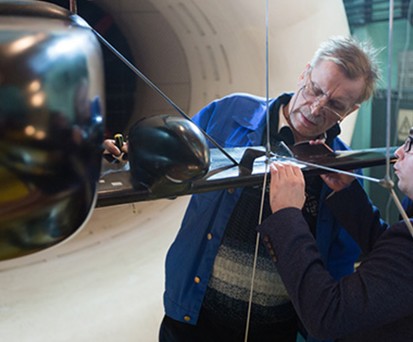 Forscher des Tsagi schauen sich ein Modell des neuen Fliegers an. Sie ...