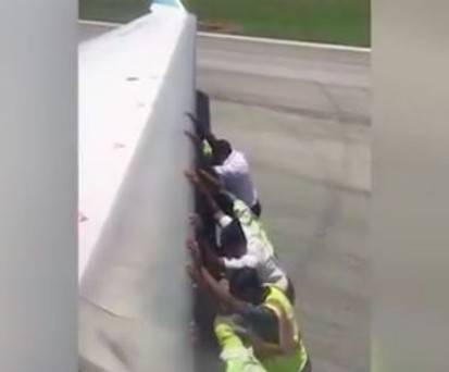 Personal schiebt einen Jet aus misslicher Lage weg