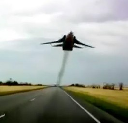 Ziemlich tief fliegt diese SU-24 über der Straße.