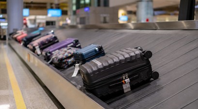 Koffer auf dem Gepäckband am Flughafen: immer seltener warten Reisende vergebens.