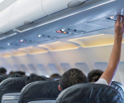 Ein Mann regelt die Luftzufuhr an seinem Sitz: Heiße Flugzeugkabinen werden zunehmend zum Problem.