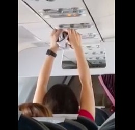 Frau trocknet Unterhose mit der Flugzeuglüftung