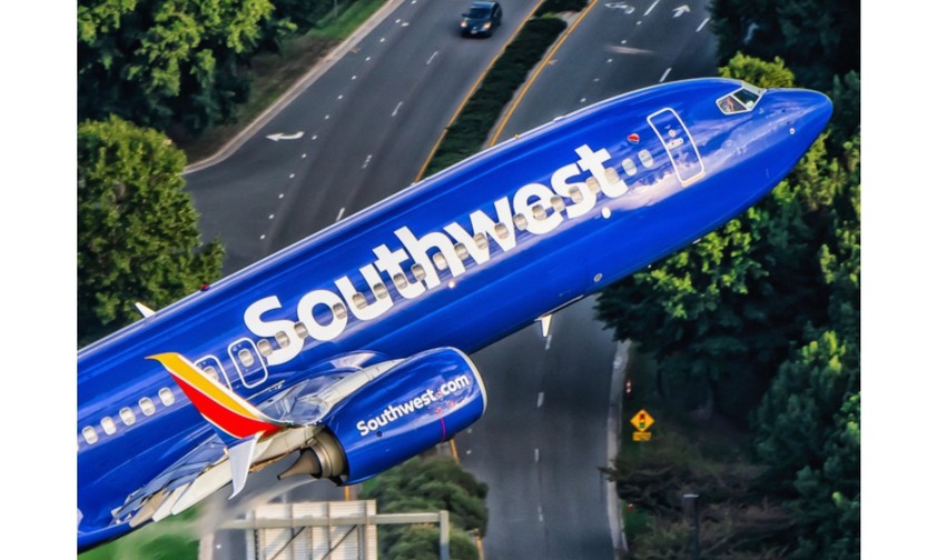 Boeing 737-800 von Kapitän Ted Orris beim Abschiedsflug: Die Aufnahme wurde aus einem Hubschrauber fotografiert, in die Kamera winkt Orris' Kopilot.