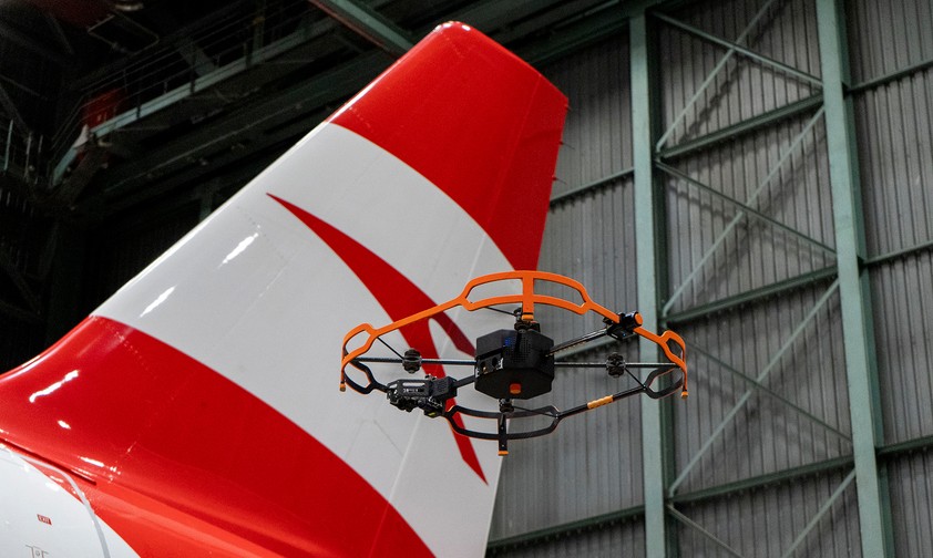 Die Drohne neben dem Heck eins Airbus-Jets von Austrian Airlines. Sie nimmt jede Sekunde ein hochauflösendes ...