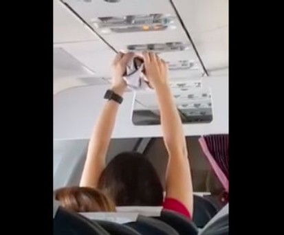 Frau trocknet Unterhose mit der Flugzeuglüftung