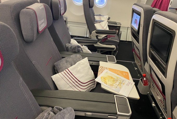 In der Premium Economy beträgt der Sitzabstand 38 Zoll, die Sitze lassen sich zudem weiter nach hinten stellen, und es gibt ein anderes Verpflegungsangebot, sowie Decken und Kissen. Die kann man in der günstigeren Klasse dazu kaufen.