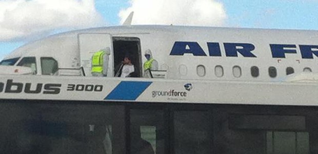 Männer mit Schutzanzügen vor dem Flugzeug: Noch hat sich der Verdacht nicht bestätigt.