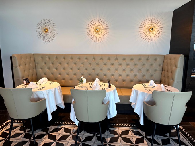 First-Class-Flair: Weisse Tischtücher prägen den Restaurantbereich der Aspire Suite Lounge.