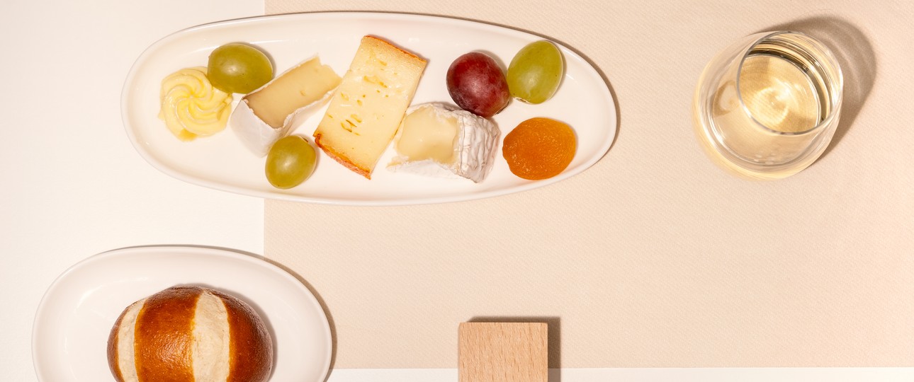 Käseplatte mit einem Glas Weißwein - elegant serviert.