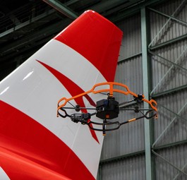 Die Drohne neben dem Heck eins Airbus-Jets von Austrian Airlines. Sie nimmt jede Sekunde ein hochauflösendes ...
