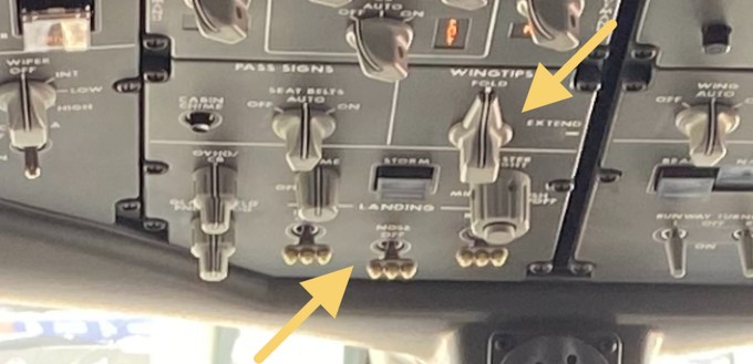 Im Cockpit der Boeing 777X gibt es über Kopf gleich zwei Dinge zu sehen: Der linke Pfeil markiert die scheinwerferförmigen Schalter für die Landescheinwerfer. Der rechte Pfeil zeigt auf den Knopf, mit dem die Flügelspitzen der 777X ein- und ausgeklappt werden - eine Premiere bei einem Verkehrsflugzeug.