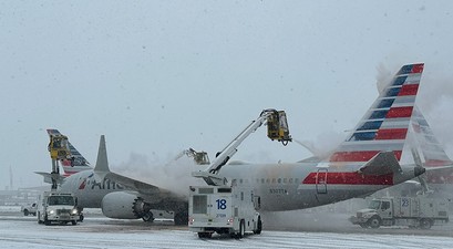 American-Airlines-Flugzeuge werden enteist: Ein Wintereinbruch für zu hunderten von Flugausfällen.