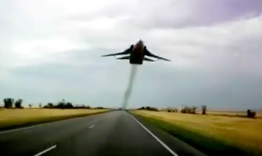Ziemlich tief fliegt diese SU-24 über der Straße.