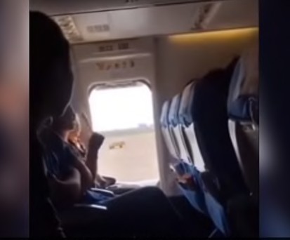 Frau öffnet Notausgang für etwas Luft